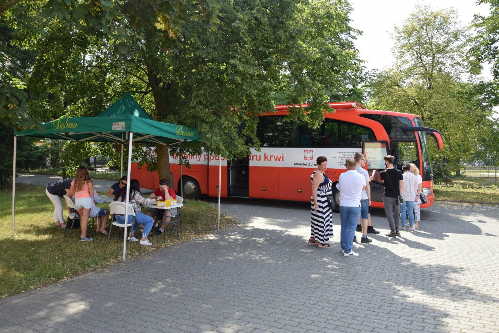 Ludzie stoją w kolejce do krwiobusa 