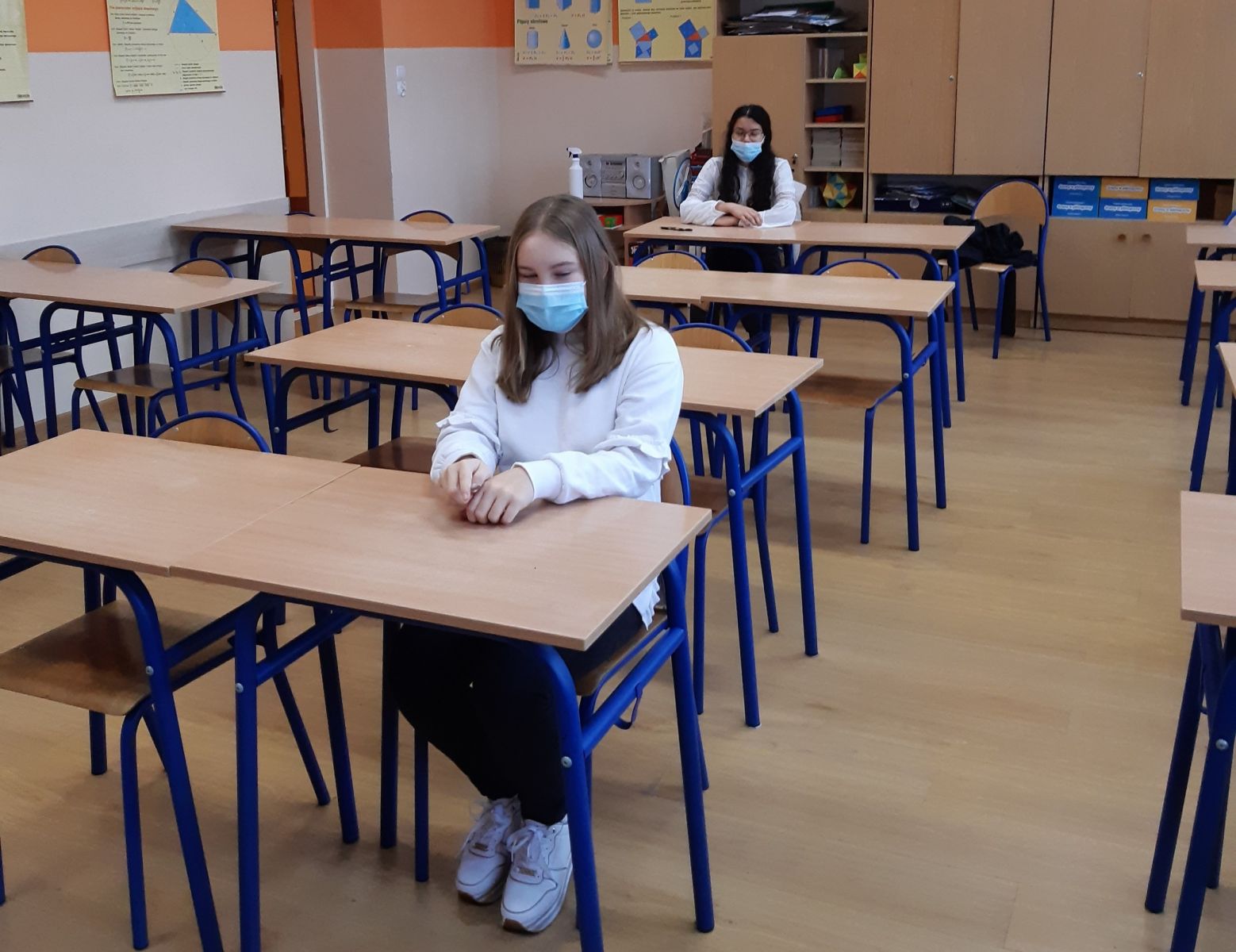 Powiększ zdjęcie. Uczniowie w maseczkach siedzą w ławkach