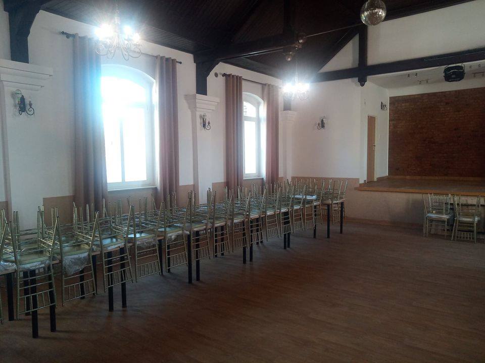 Sala w świetlicy Warnice. Stoły, krzesła, zasłony