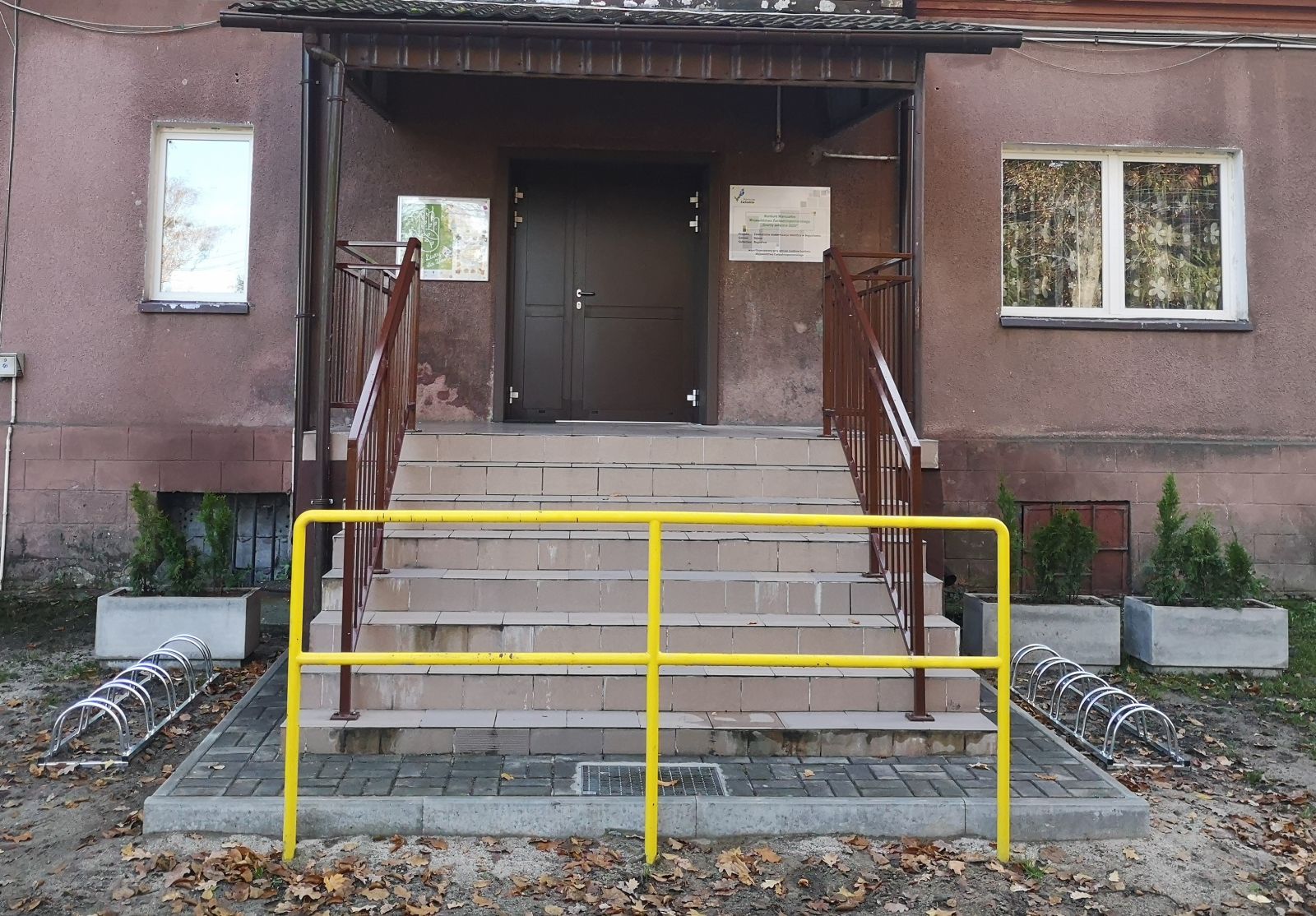 Wejście na świetlicę w Bogusławiu, stojaki na rowery, betonowe donice