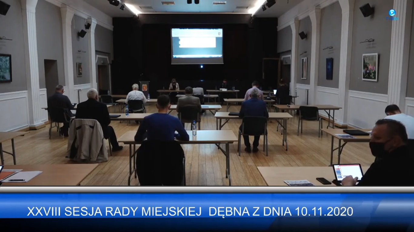 Powiększ zdjęcie. Sesja na sali. radni siedzą każdy przy swojej ławce w odległości tyłem do kamery