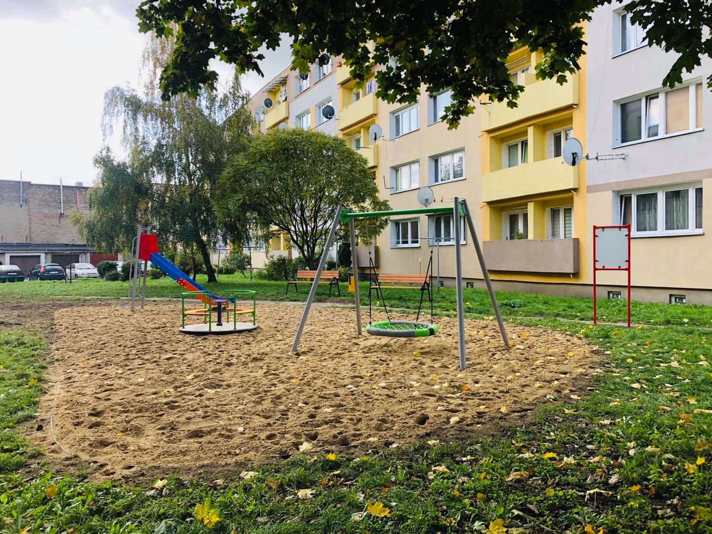 Powiększ zdjęcie.Plac zabaw, huśtawka, karuzela, zjeżdżalnia, blok