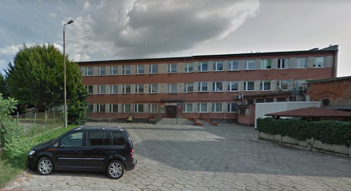 Powiększ zdjęcie. Biurowiec, czarny samochód, drzewo, niebo