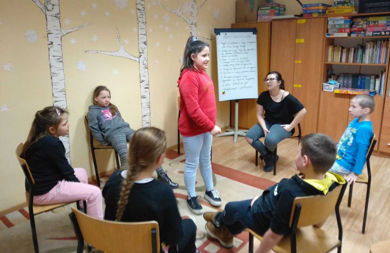 Zajęcia w świetlicy dzieci siedzą w kręgu, jedno stoi w środku