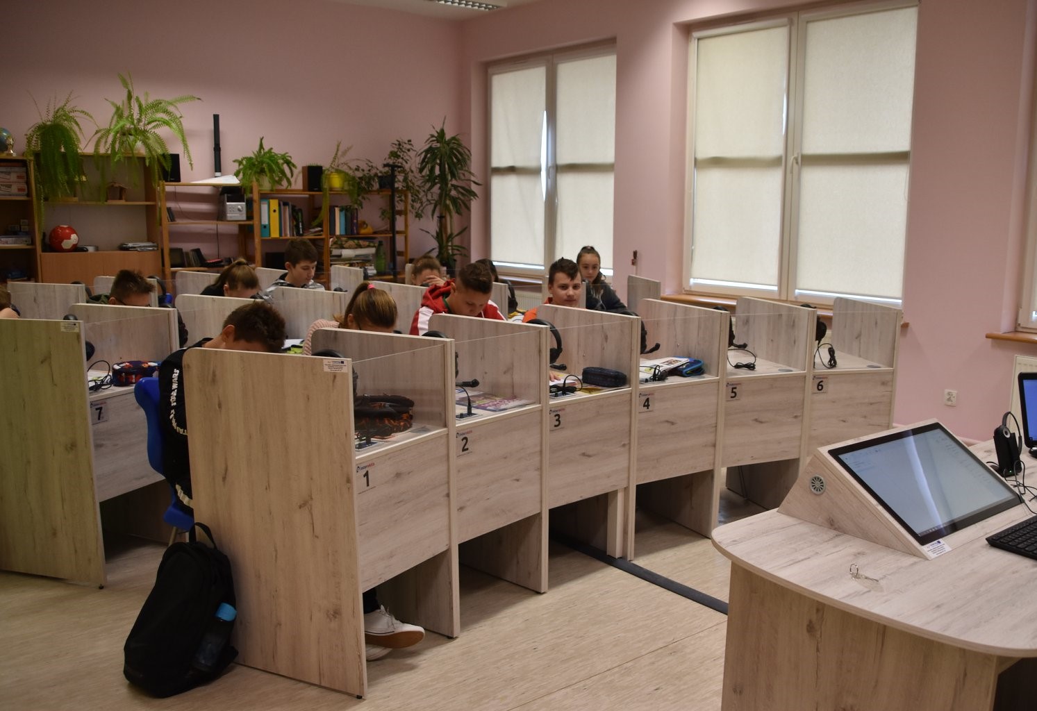 Powiększ zdjęcie. Uczniowie siedzą w pracowni językowej w boksach
