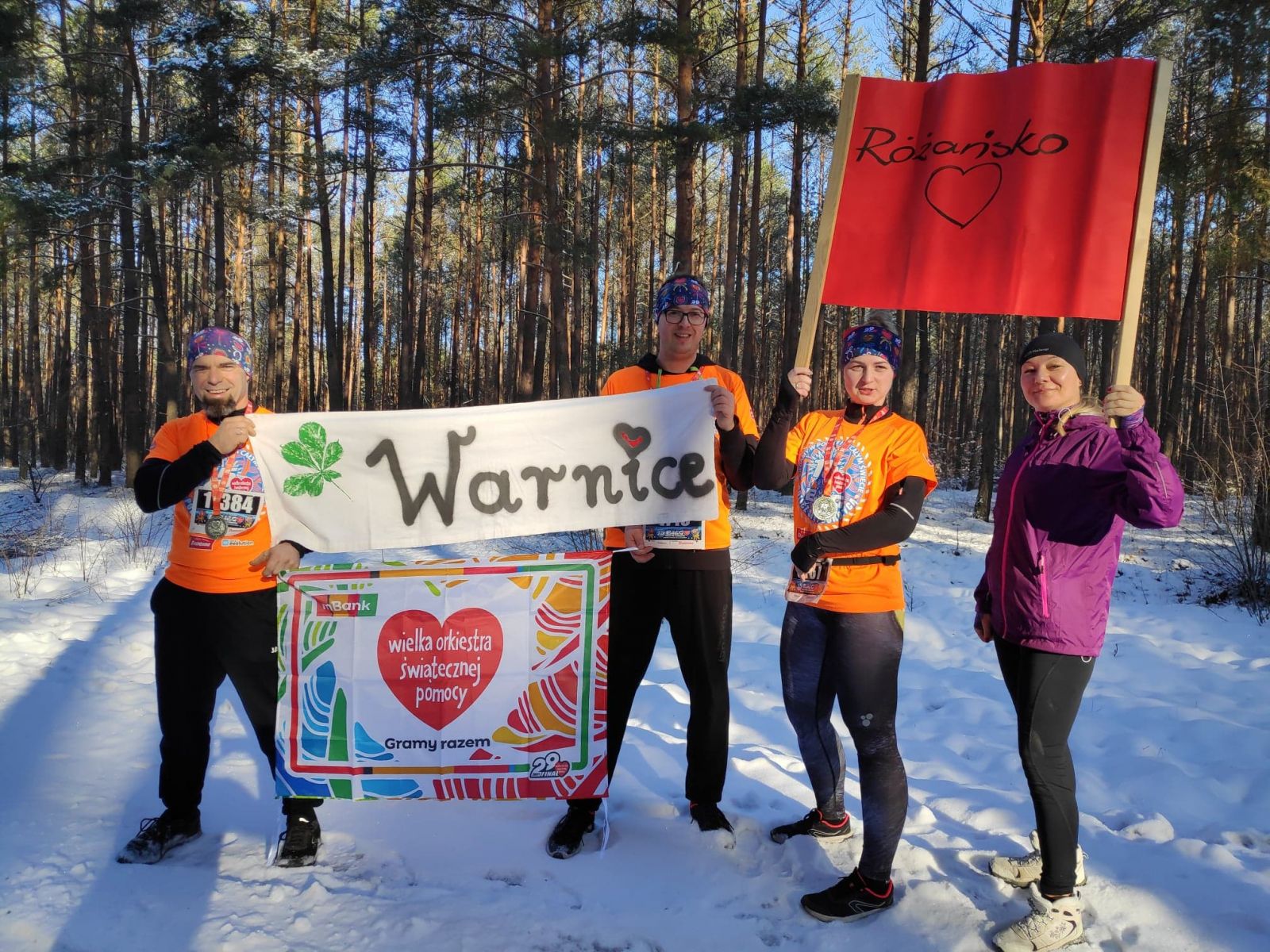 Mieszkańcy ubrani na sportowo trzymają baner Warnice, Różańsko,WOŚP, śnieg, las 