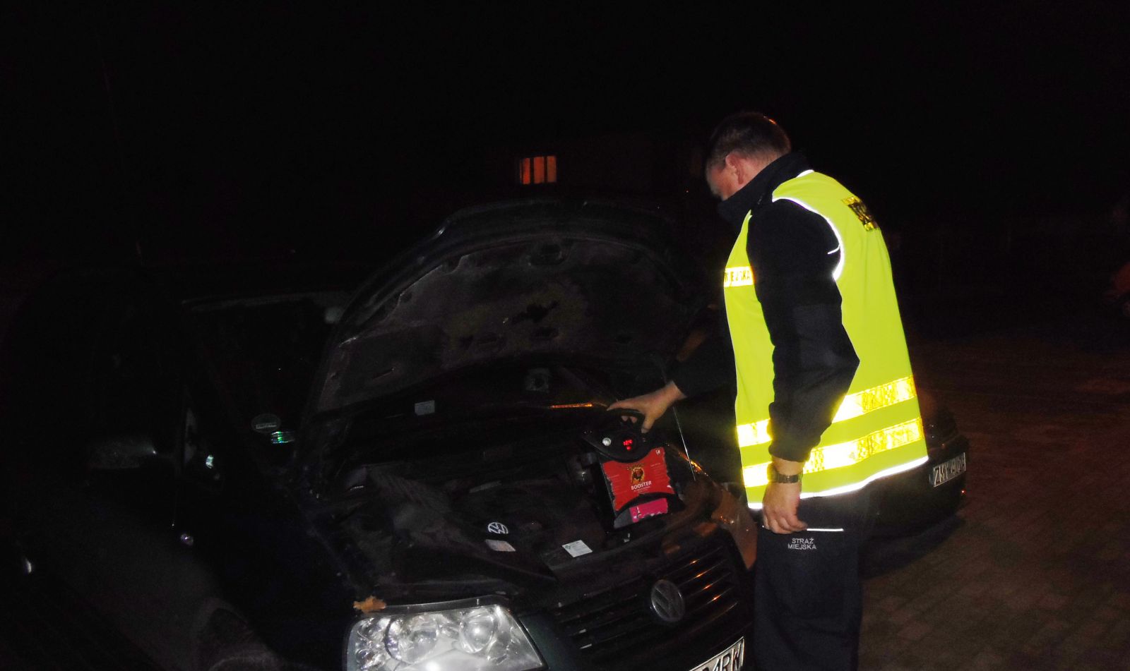 Powiększ zdjęcie. Strażnik miejski uruchamia samochód za pomocą urządzenia