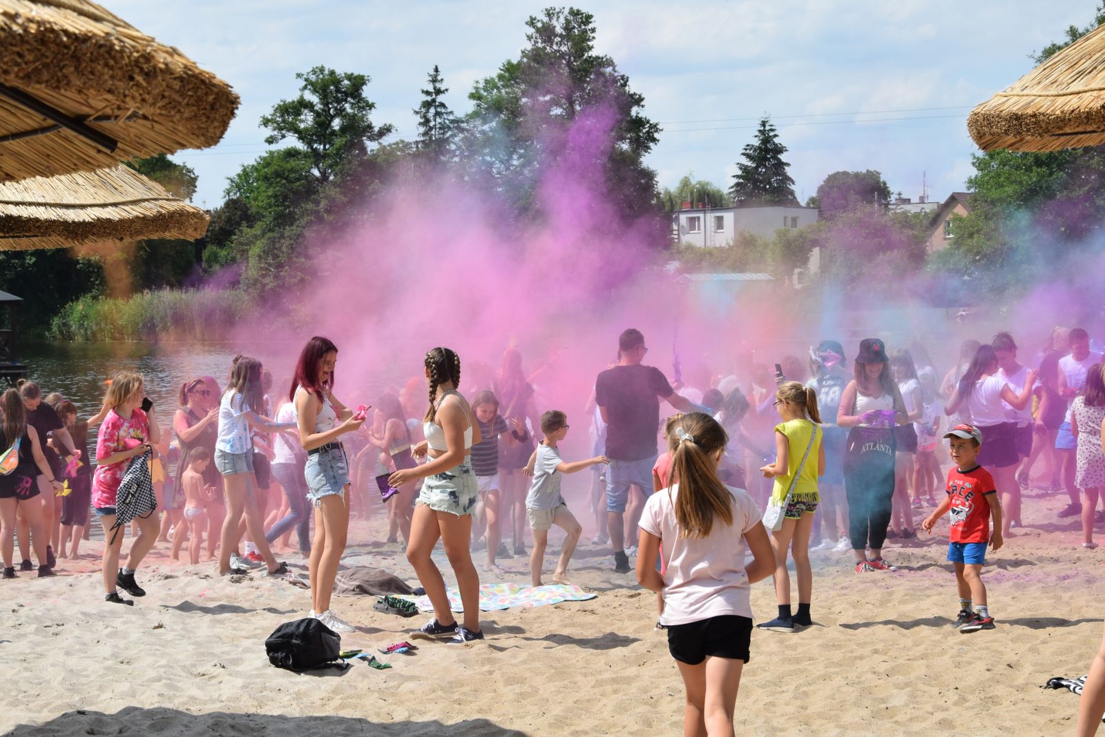 Powiększ zdjęcie. Chmura kolorów nad ludźmi na plaży 