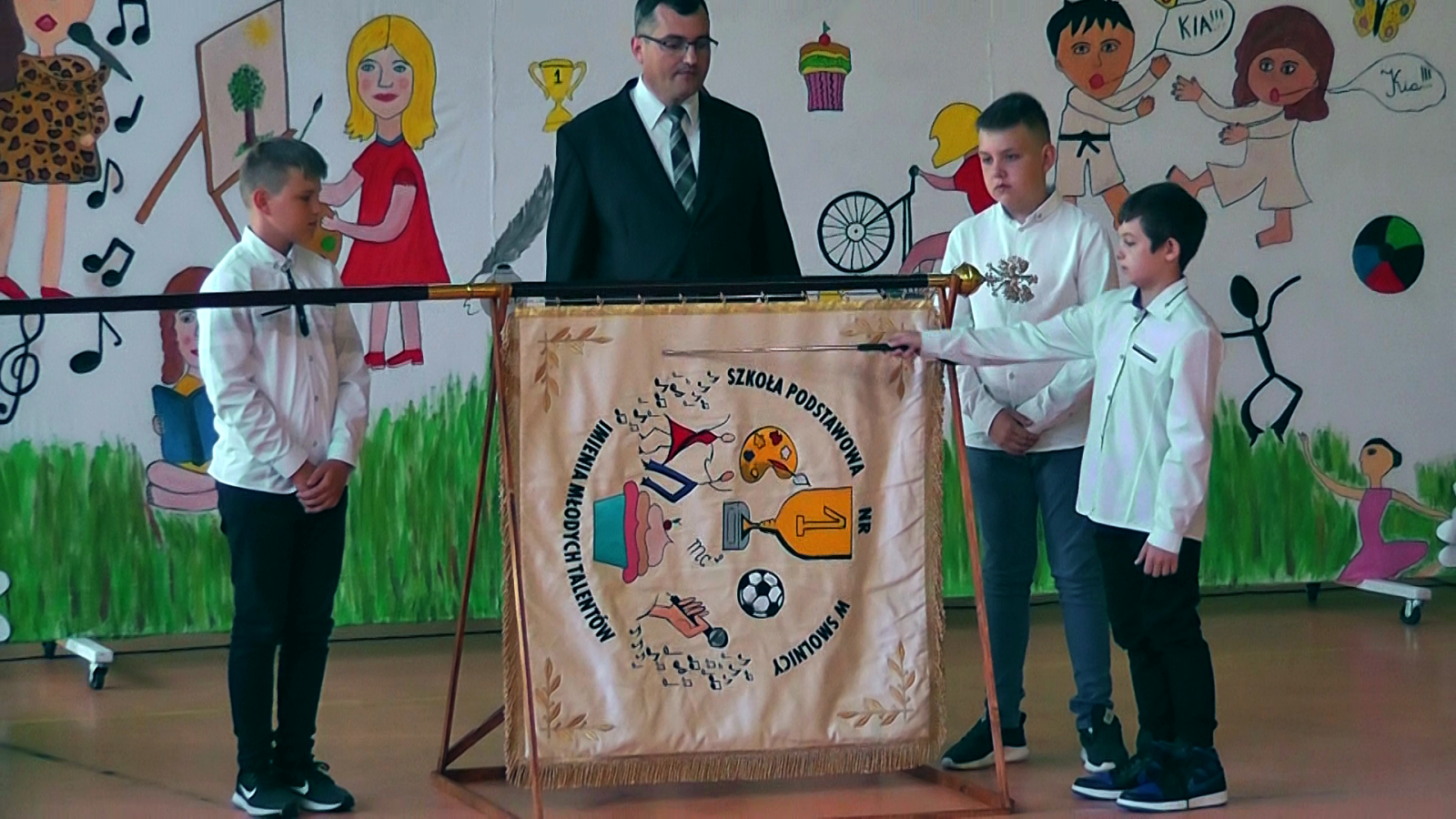 Powiększ zdjęcie. Sztandar szkoły, obok uczniowie