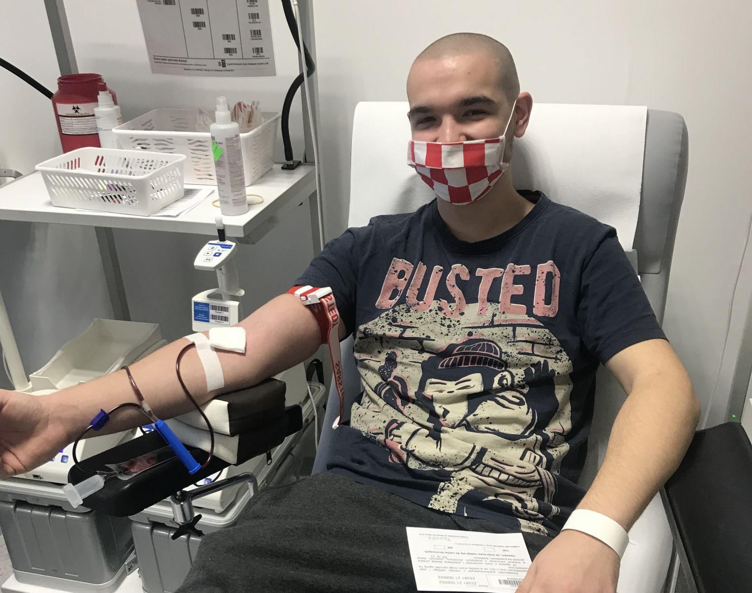 Młody chłopak w maseczce oddaje krew
