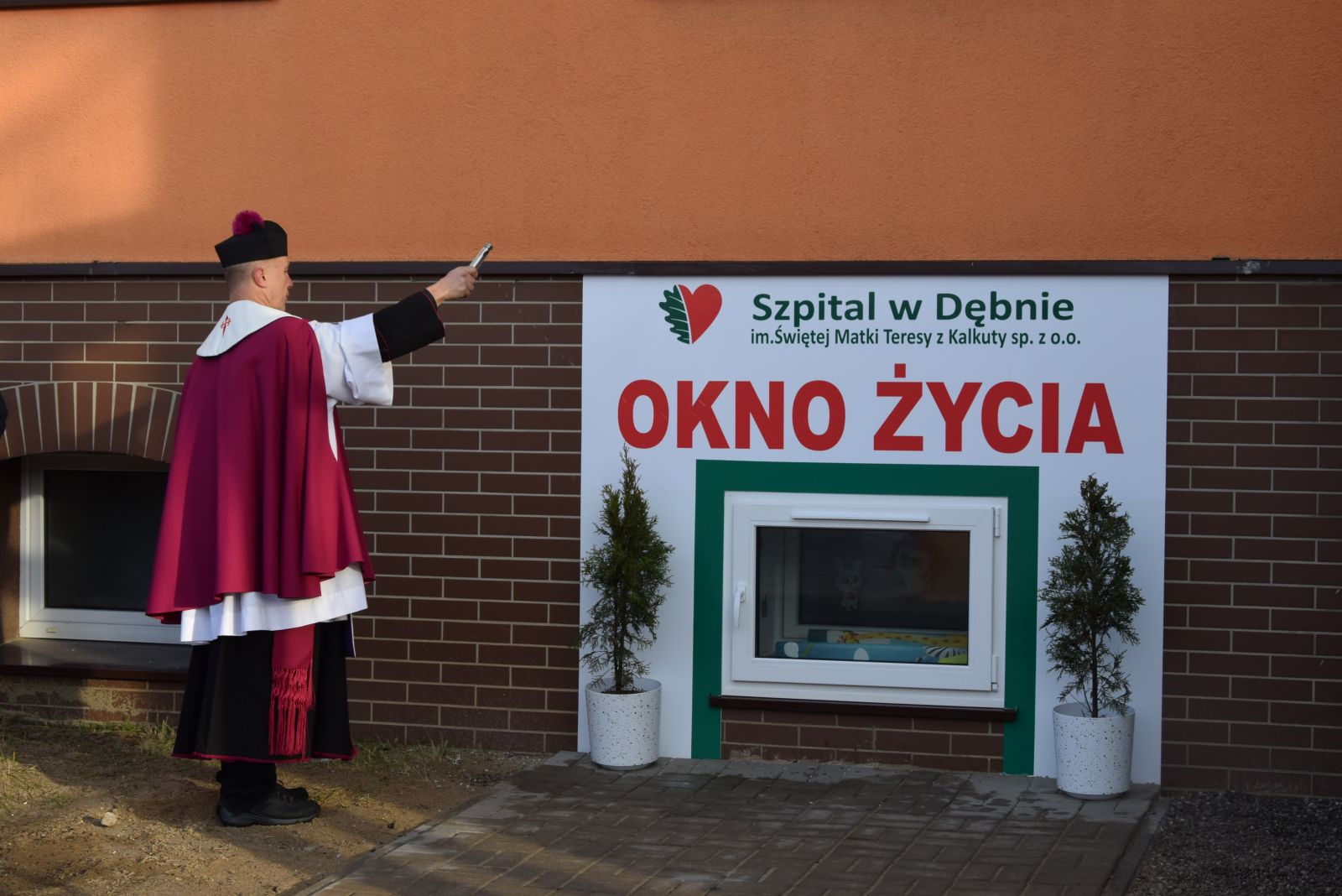 Powiększ zdjęcie. Ksiadz poświęca okno życia 