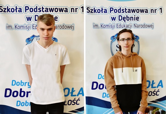 Powiesz zdjęcie. Dwóch uczniów stoi, w tle baner szkoły
