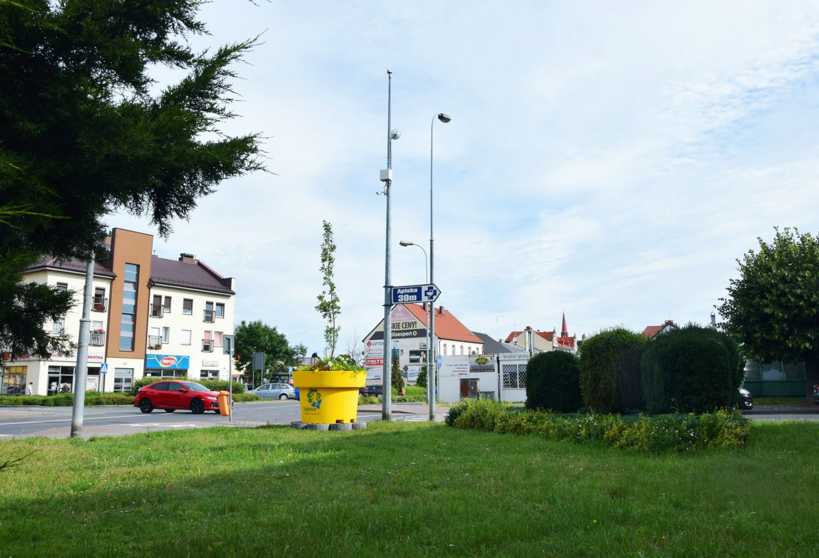 Żółta donica XL przy skrzyżowaniu placu Zwycięstwa i ulicy Bohaterów Września, niebo, krzewy, 