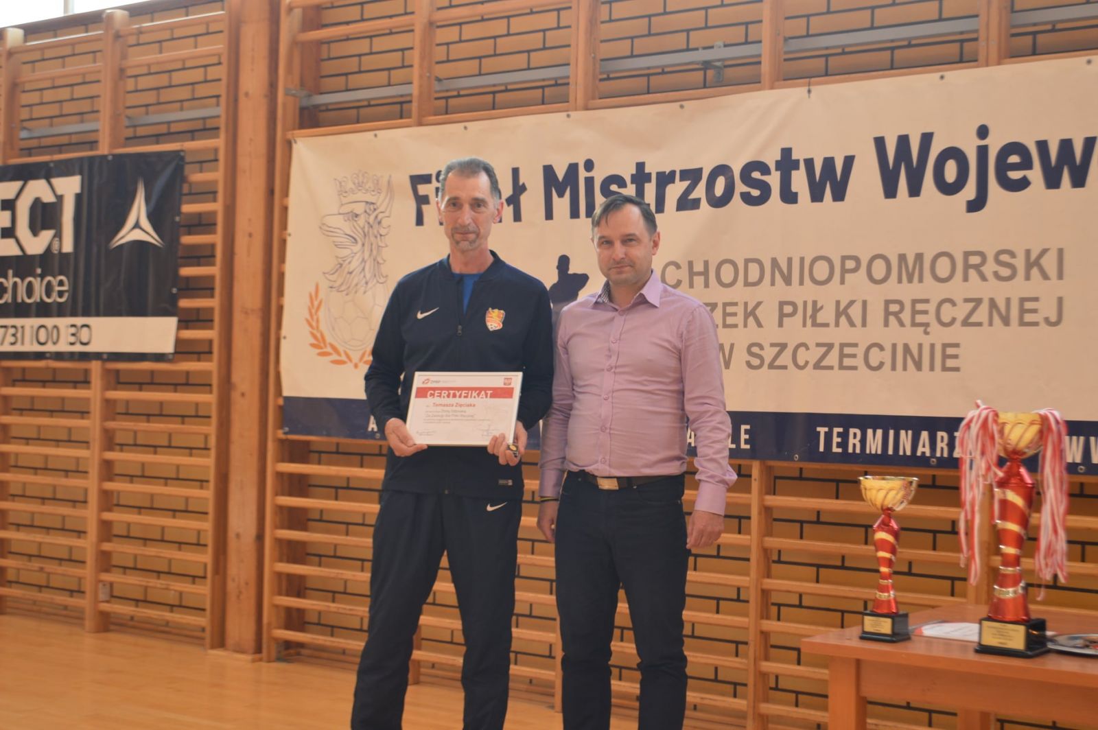 Powiększ zdjęcie.Od lewej Tomasz Zięciak trzyma certyfikat