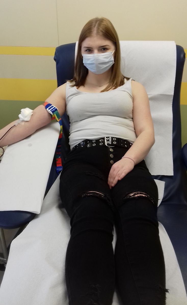 Dziewczyna w maseczce oddaje krew