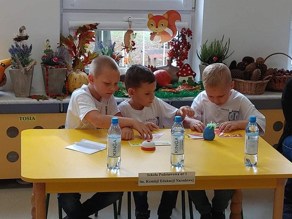 Powieksz zdjęcie. Trójka dzieci wykonują zadania.