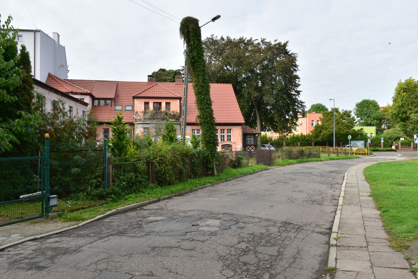 Droga z dziurami, chodniki, teren zielony, budynek, 