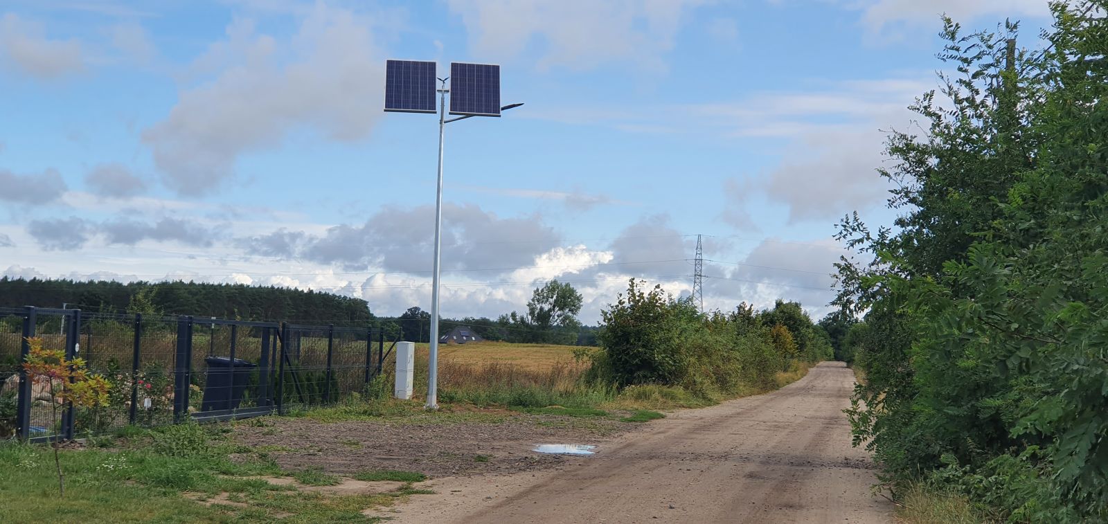 Lampa solarna, niebo, droga grutnowa, płot, drzewo