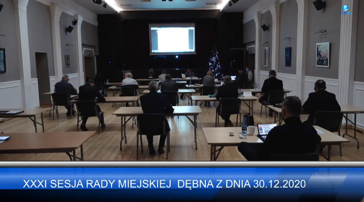Powiększ zrzut z tansmisji sesji. Radni siedzą tyłem przy stołach 
