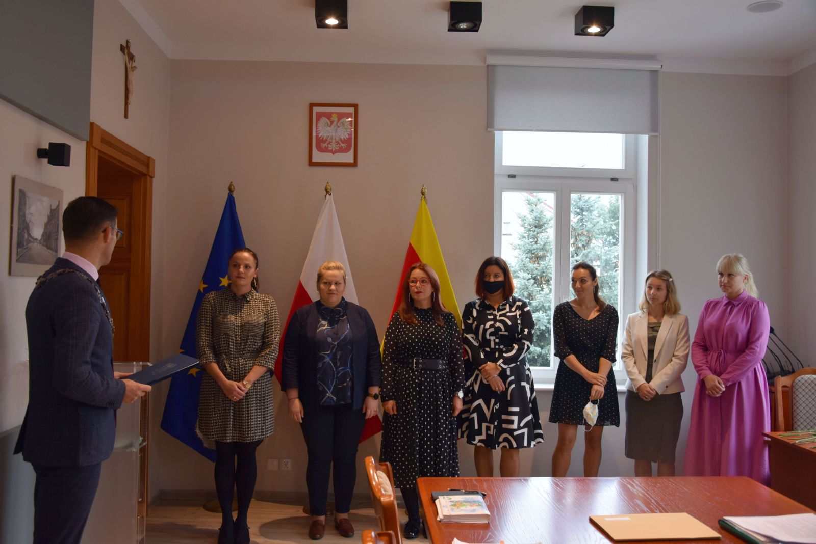 Powiększ zdjęcie. 7 kobiet stoi w rzędzie przed nimi burmistrz