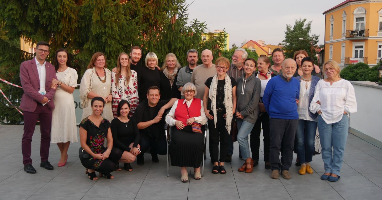 Powiększ zdjęcie. Grupa artystów, organizatorzy, burmistrz pośrodku na krześle siedzi A. Szymanek