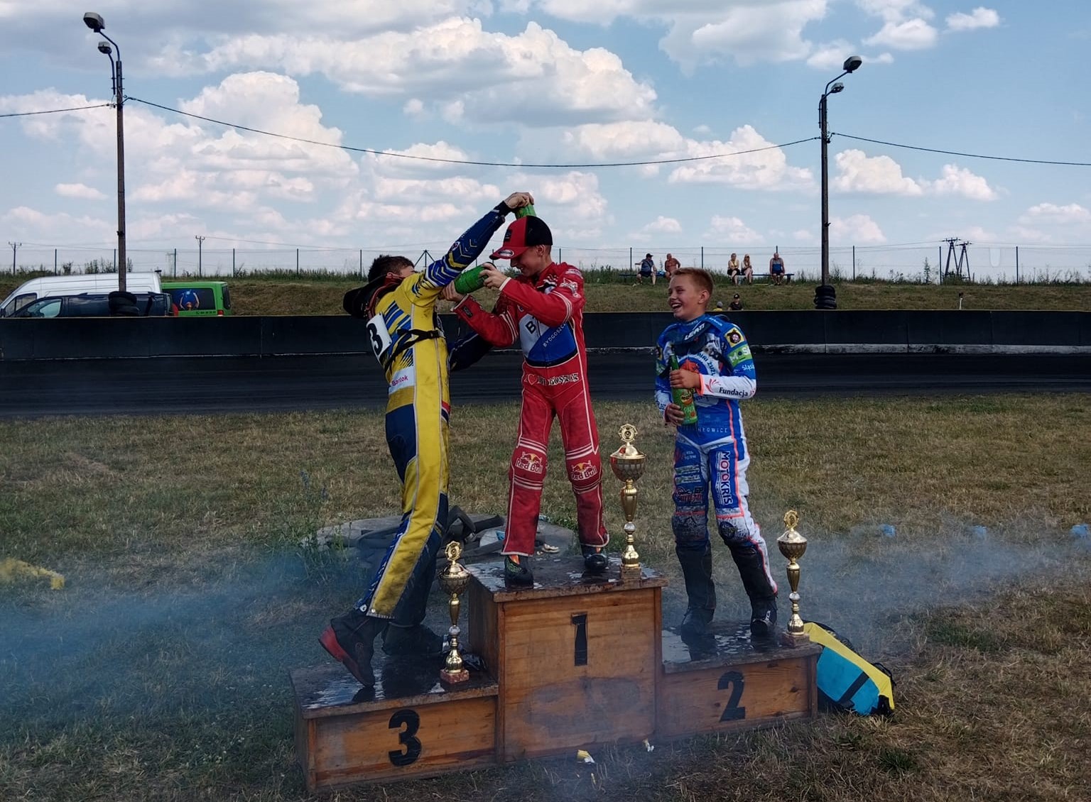 Powiększ zdjęcie. Trzech chłopców na podium 