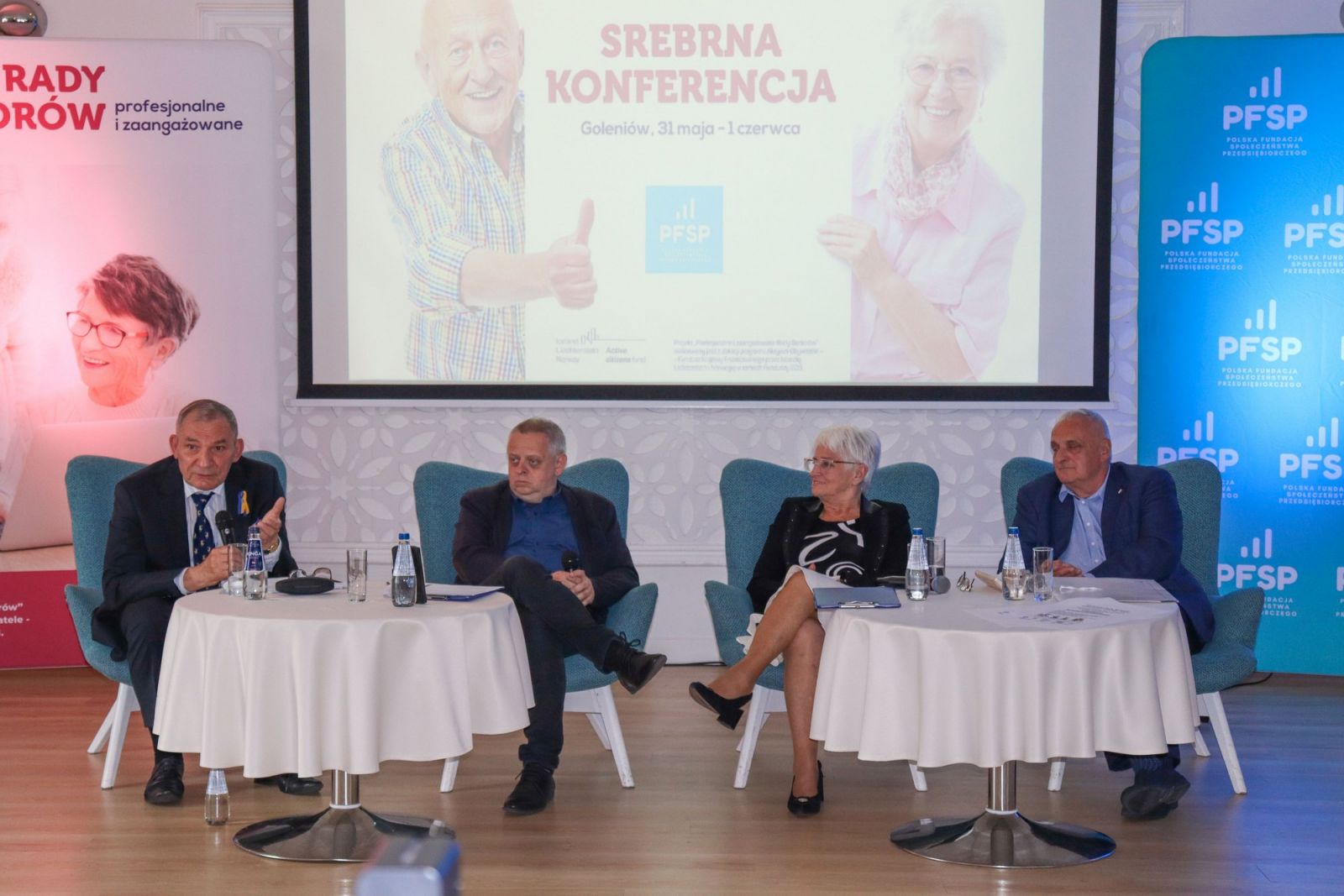Prelegenci siedzą na fotelach