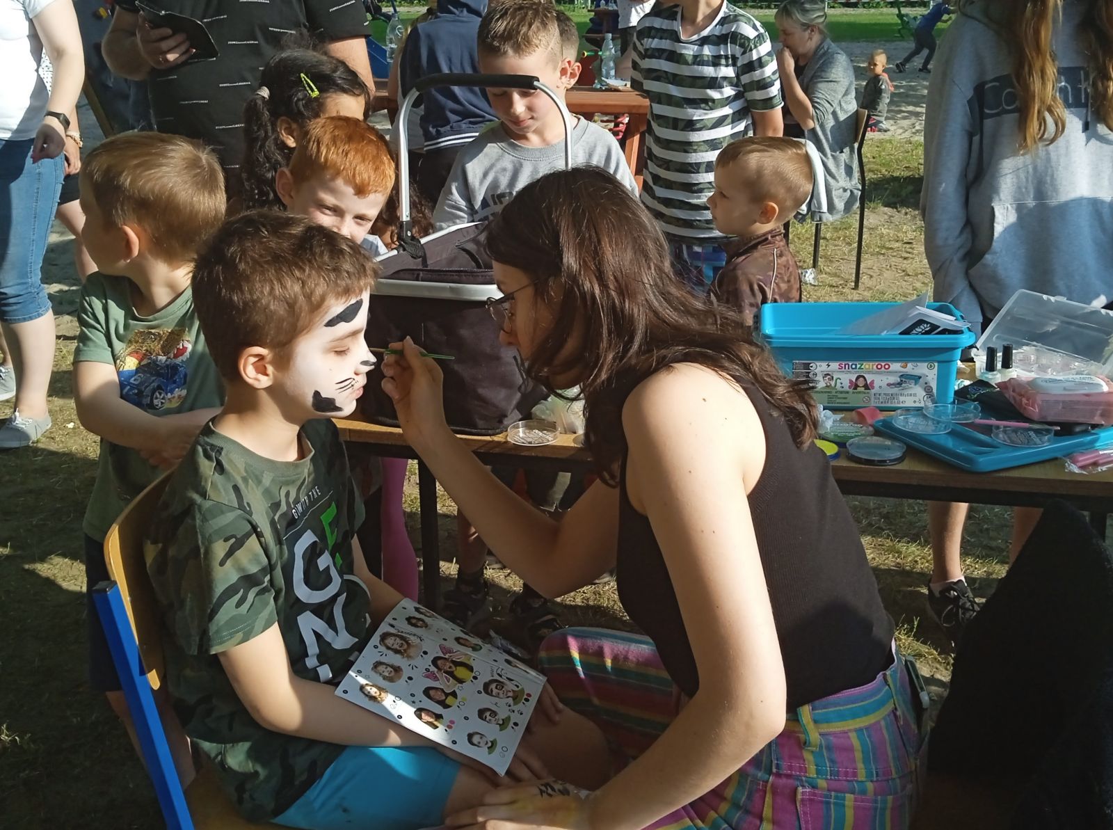 Powiększ zdjecie. Pani maluje twarz dziecku