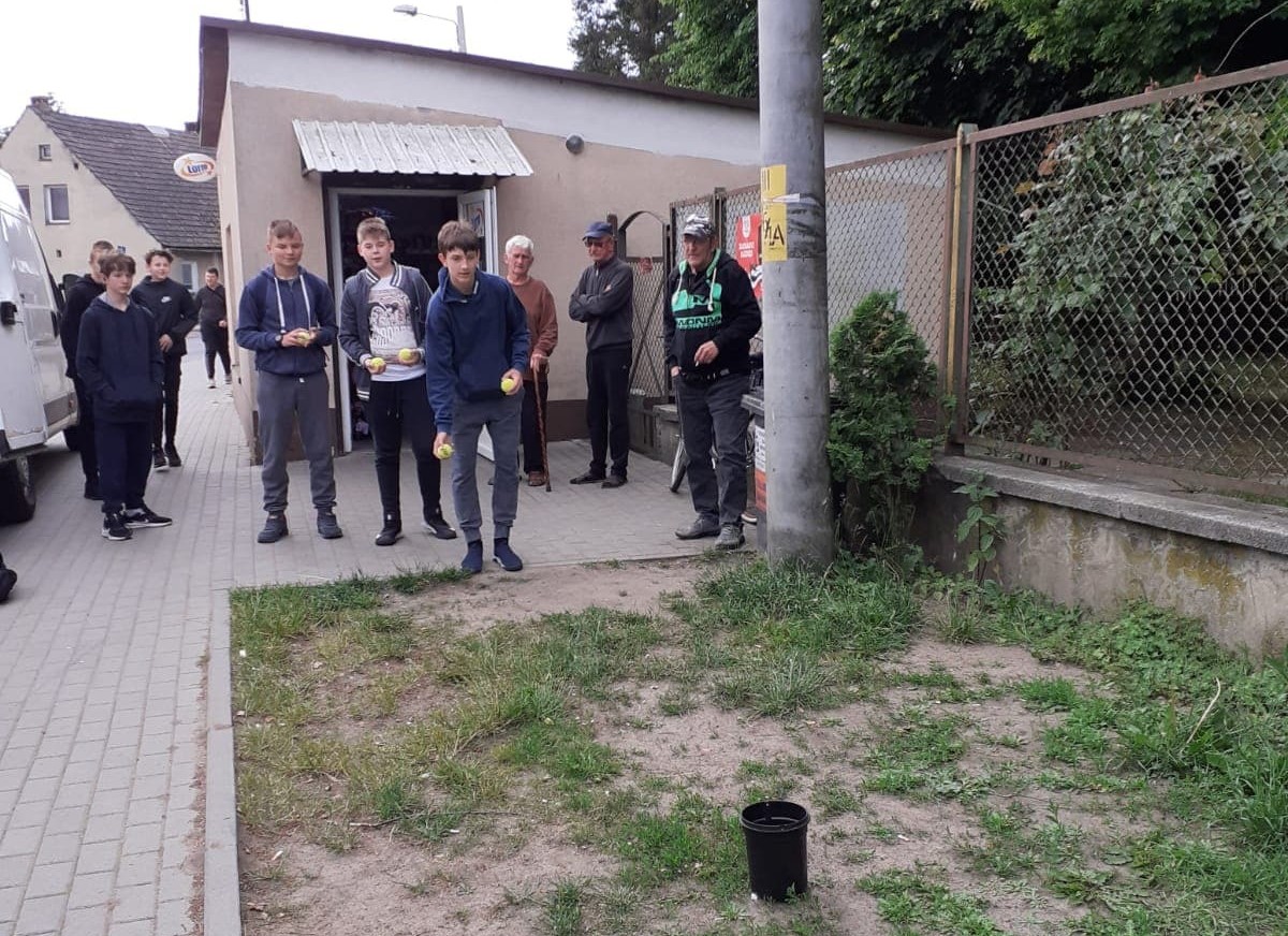 Powiększ zdjęcie. Uczeń wrzuca kamyk do celu. Jedno z zadań
