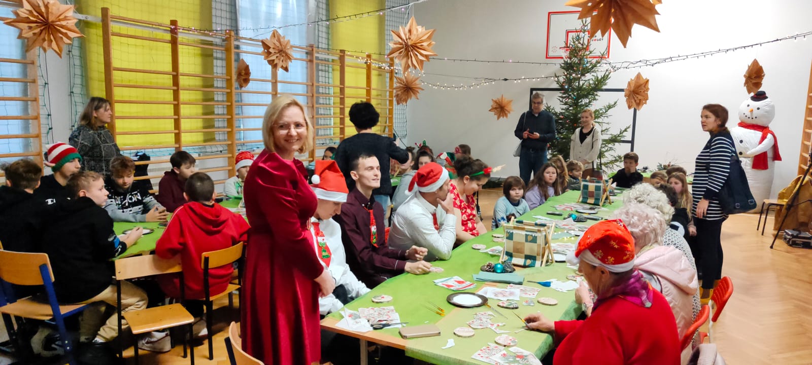 Osoby niepełnopsrawne z dziećmi siedzą przy stołach 