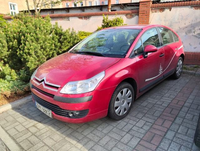 Powiększ zdjęcie. Czerwony samochód na parkingu