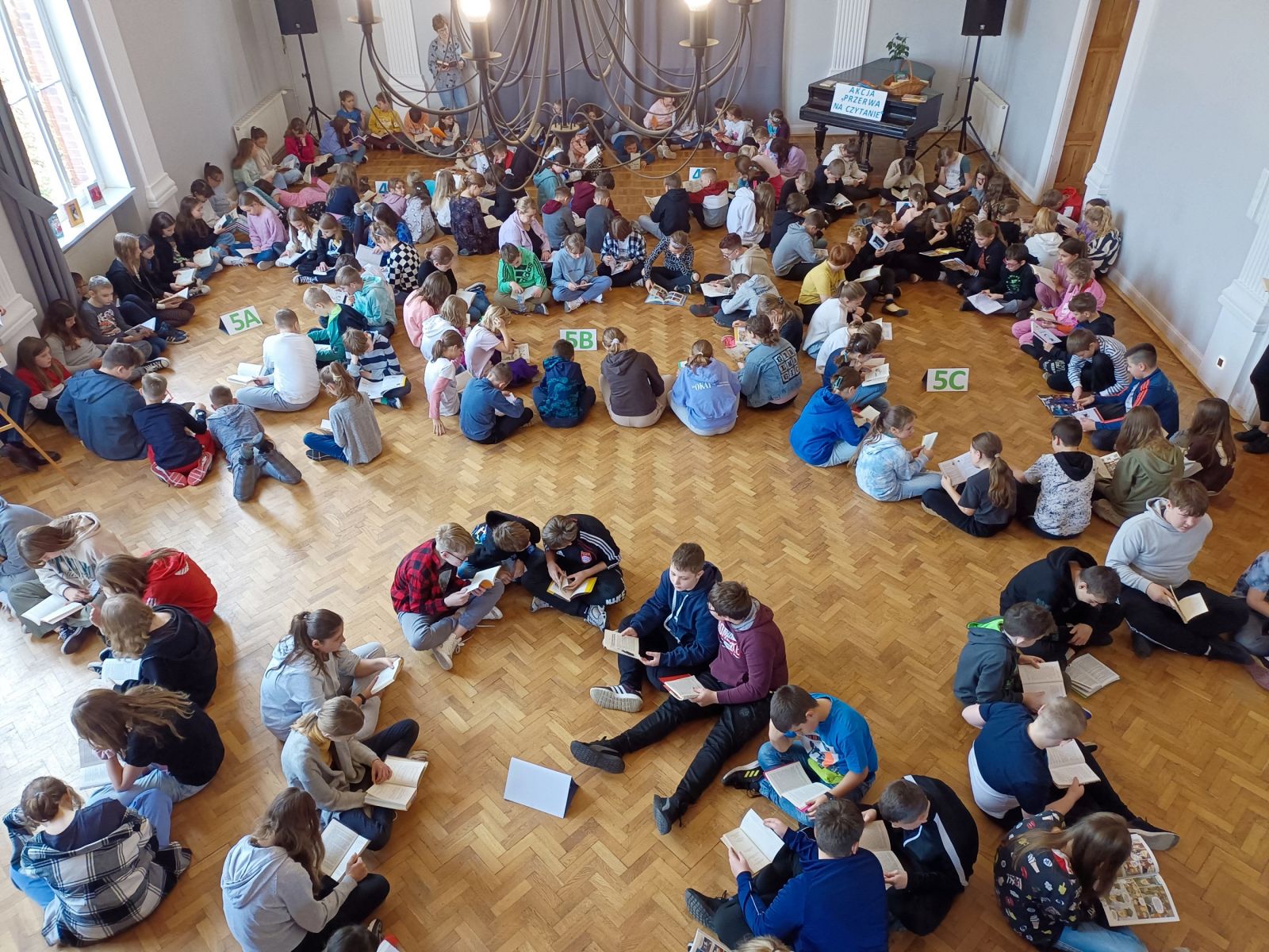 Powiększ zdjęcie. Grupa dzieci czyta książki
