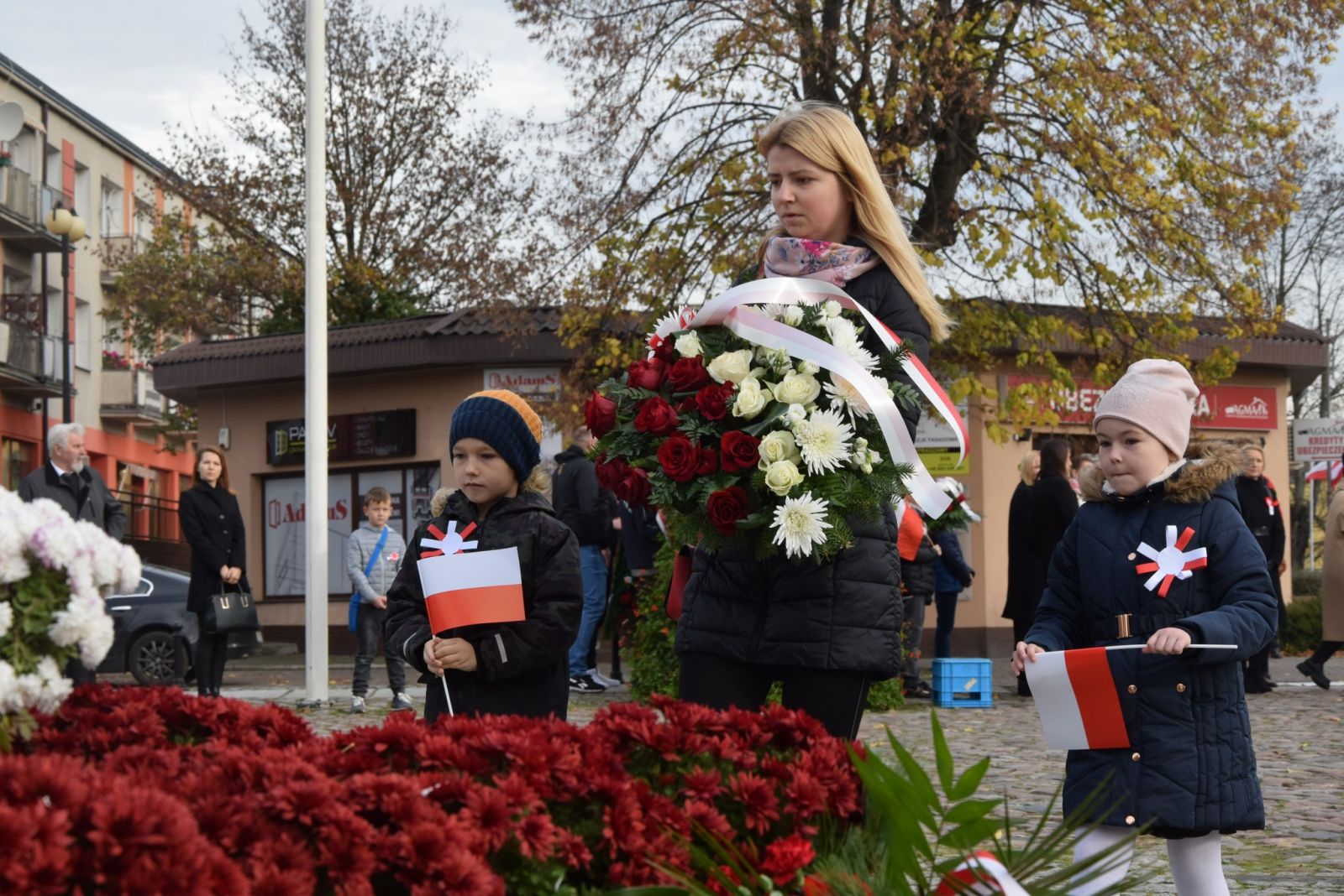 Kwiaty składa pani z dwójką dzieci