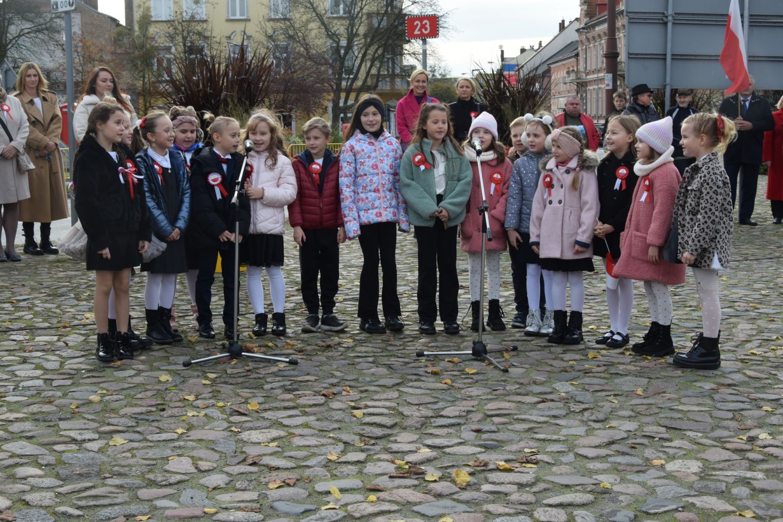 Gruap dzieci śpiewa na placu 