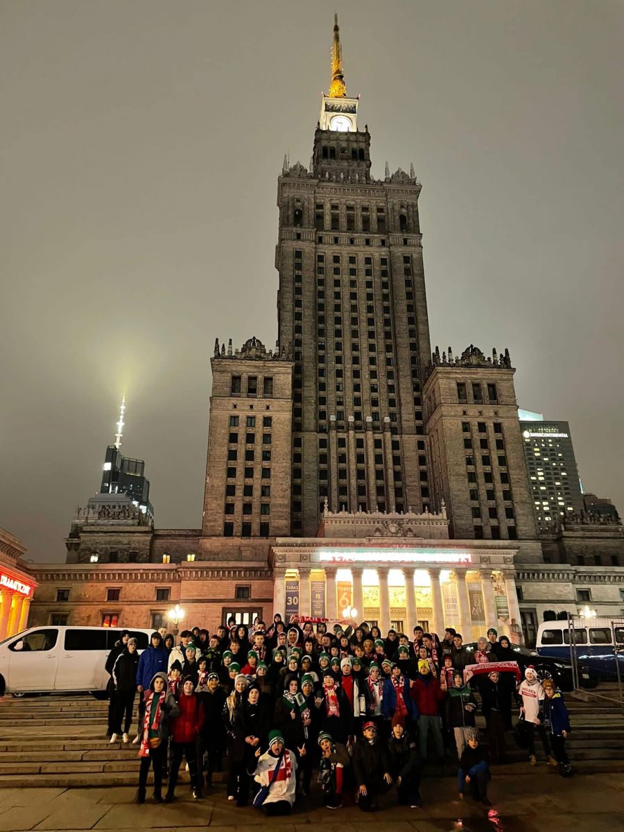 Powiększ zdjęcie. Grupa zawodników, w tle Pałac Kultury