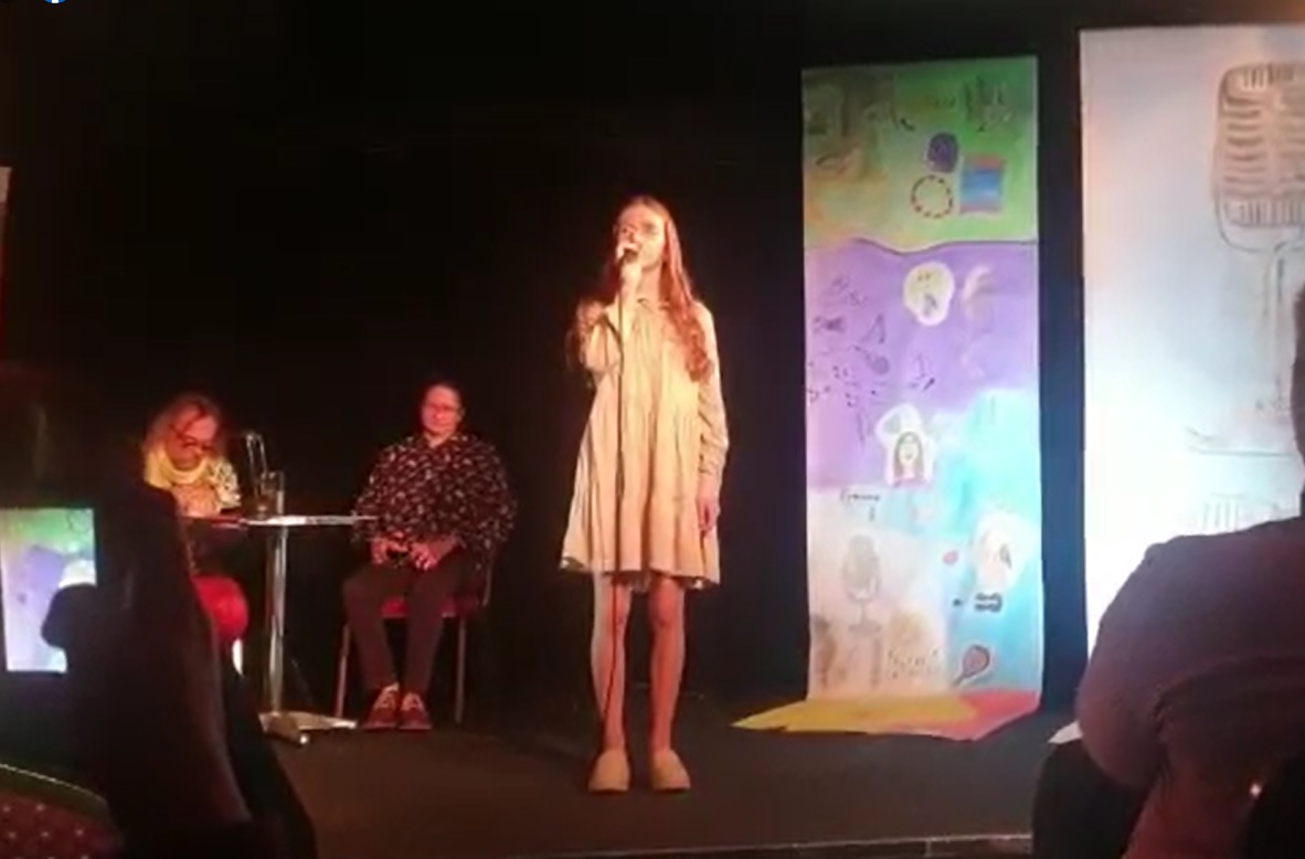 Powiększ zdjęcie. Wiktoria z mikrofonem na scenie