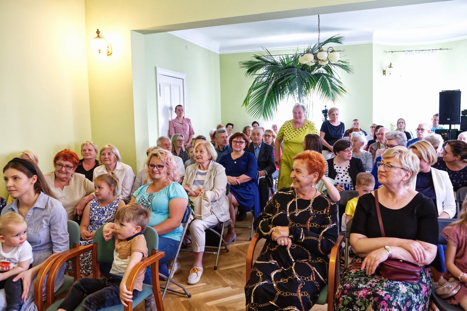Powiększ zdjęcie. Goście siedzą w sali 