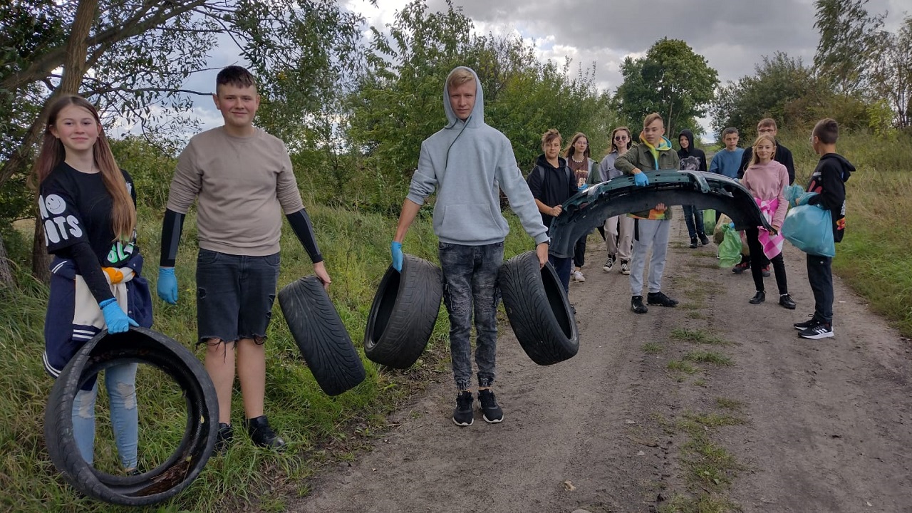 Młodzież niesie opony i częsci samochodowe
