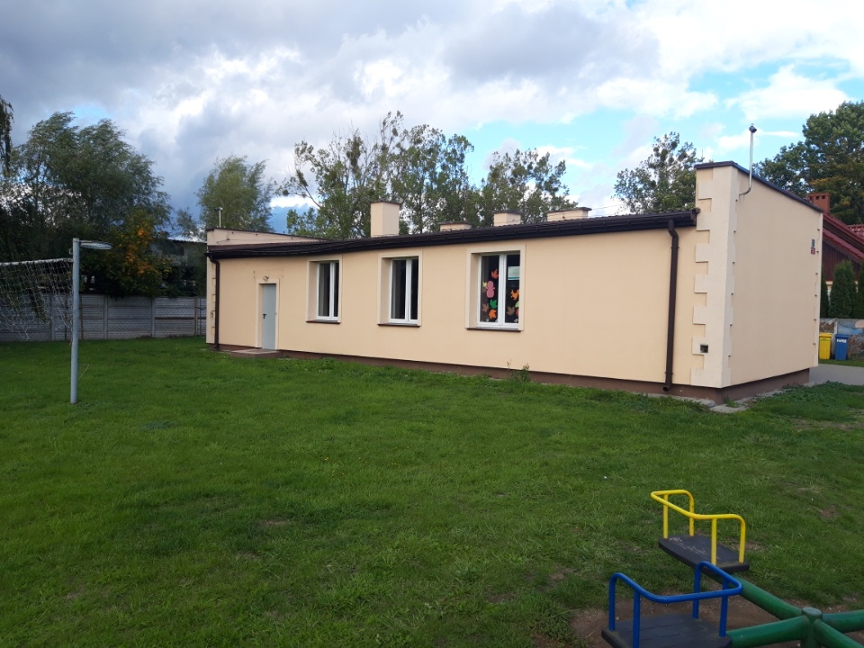 Powiększ zdjęcie. Żółty budynek świetlic, zielona trawa