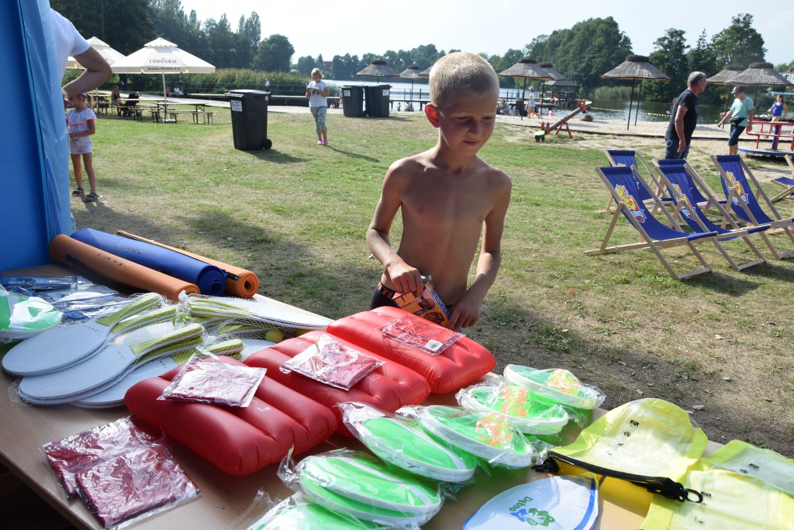 Powiększ zdjęcie. Gadżety leżą na stole chłopiec patrzy na nie 