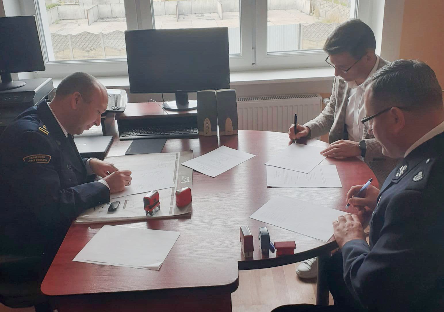 Powiększ zdjęcie. Panowie podpisują porozumienie