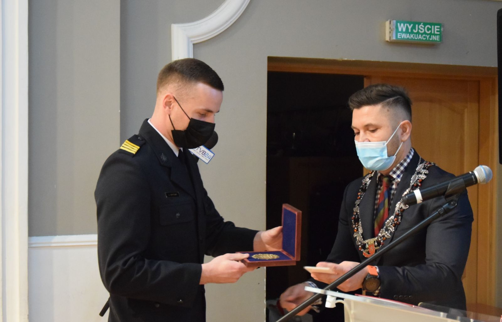 Powiększ zdjęcie. Strażak odbiera medal od przewodniczącego rady 