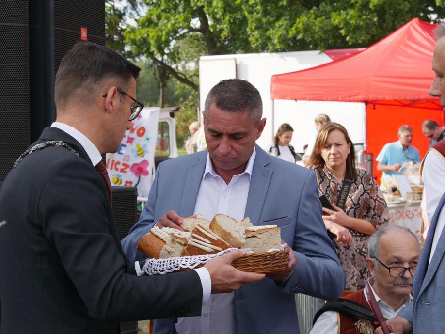 Powiększ zdjecie. Burmistrz Dębna dzieli się chlebem z sołtysem Grzymiradza