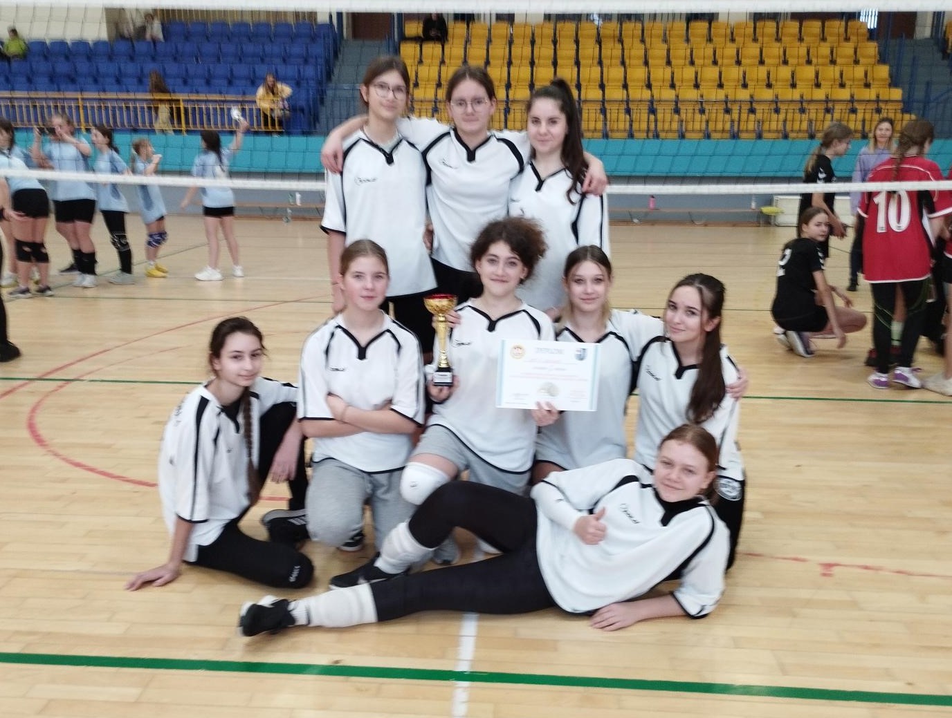 Powiększ zdjęcie. Drużyna dziewcząr z pucharem na hali
