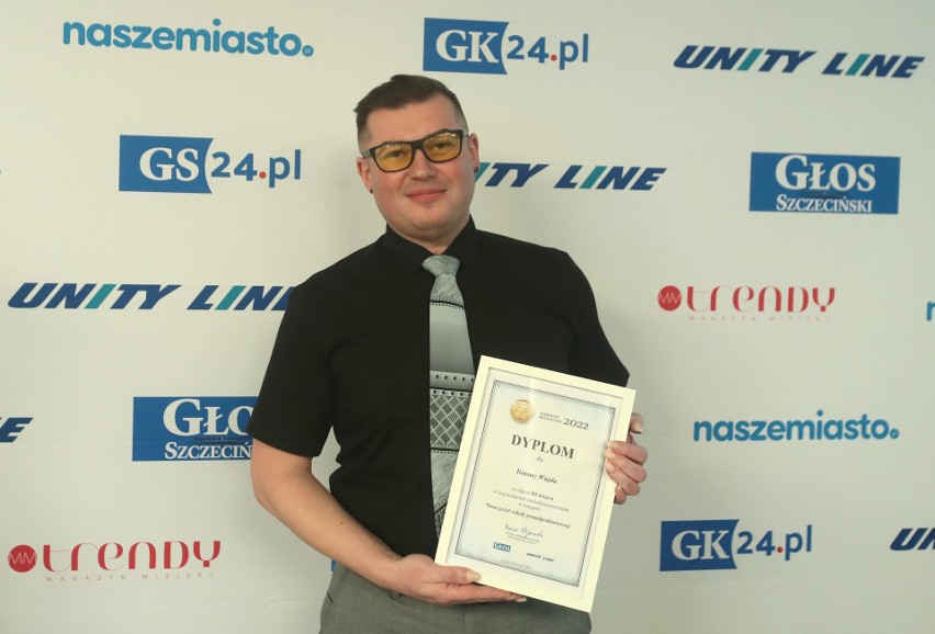 Tomasz Wujda trzyma dyplom 
