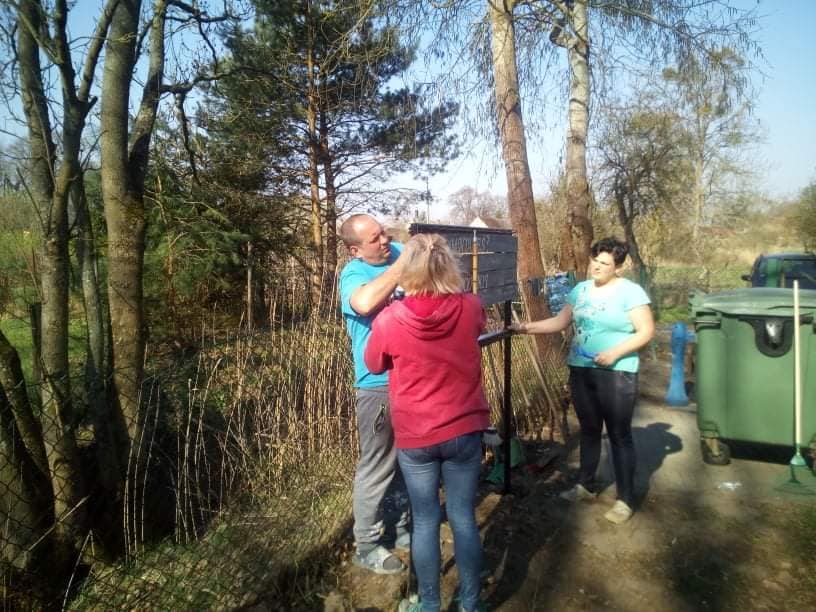 Powiększ zdjęcie. Mieszkańcy montują stojak na cmentarzu