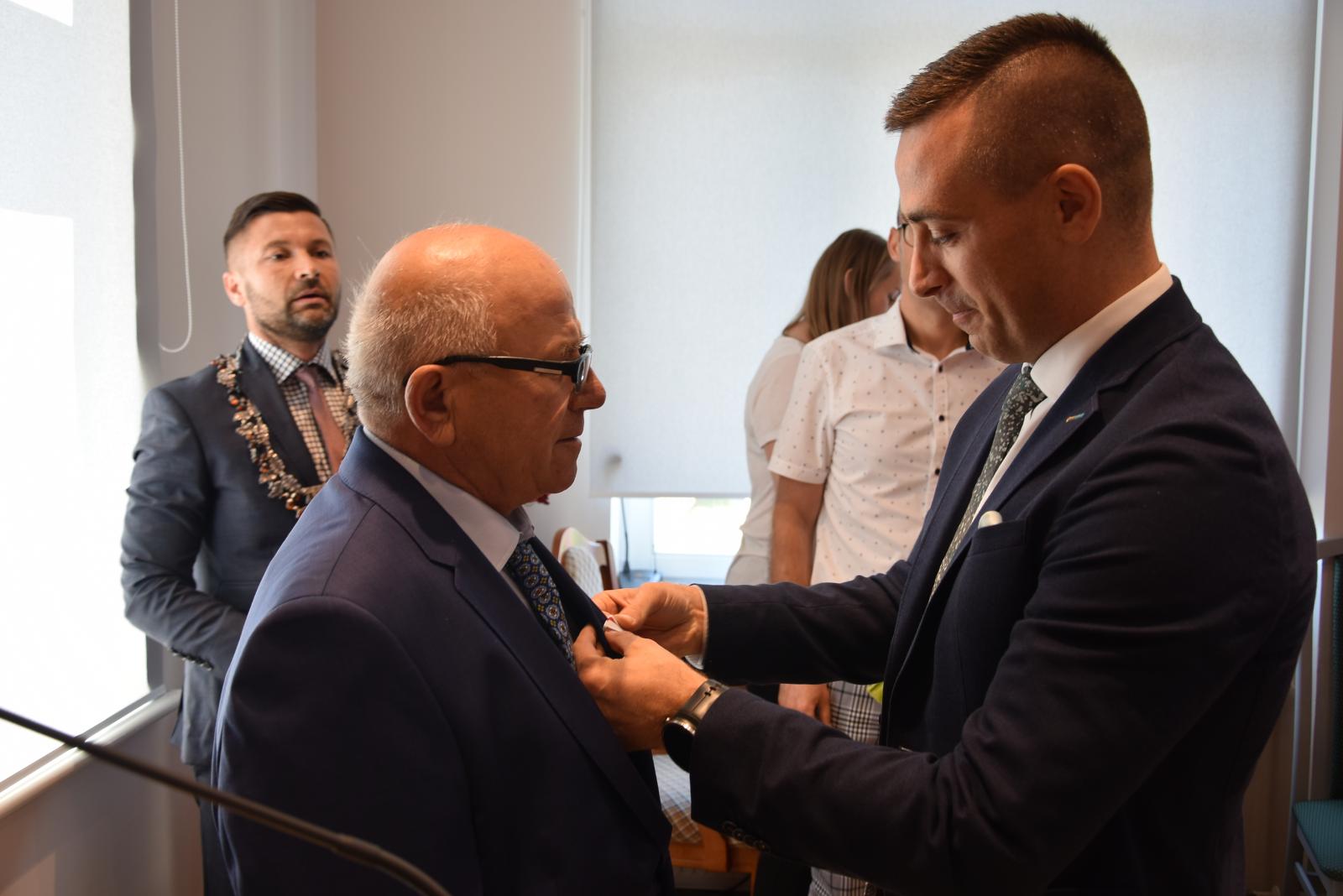 Powiększ zdjęcie. Krzysztof Barczyk Dyrektor Gabinetu Marszałka Województwa Zachodniopomorskiego wręcza medal Danielowi Bońdosowi