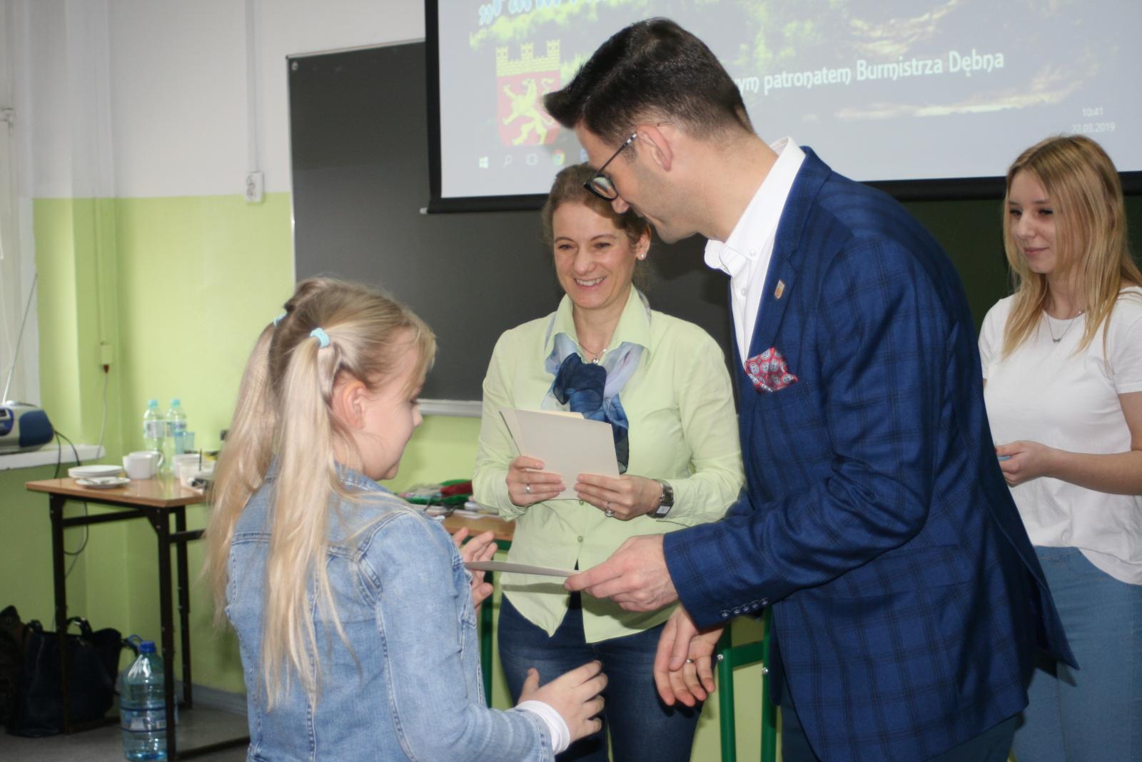 Burmistrz Dębna wręcza nagrodę laureatce konkursu plastycznego