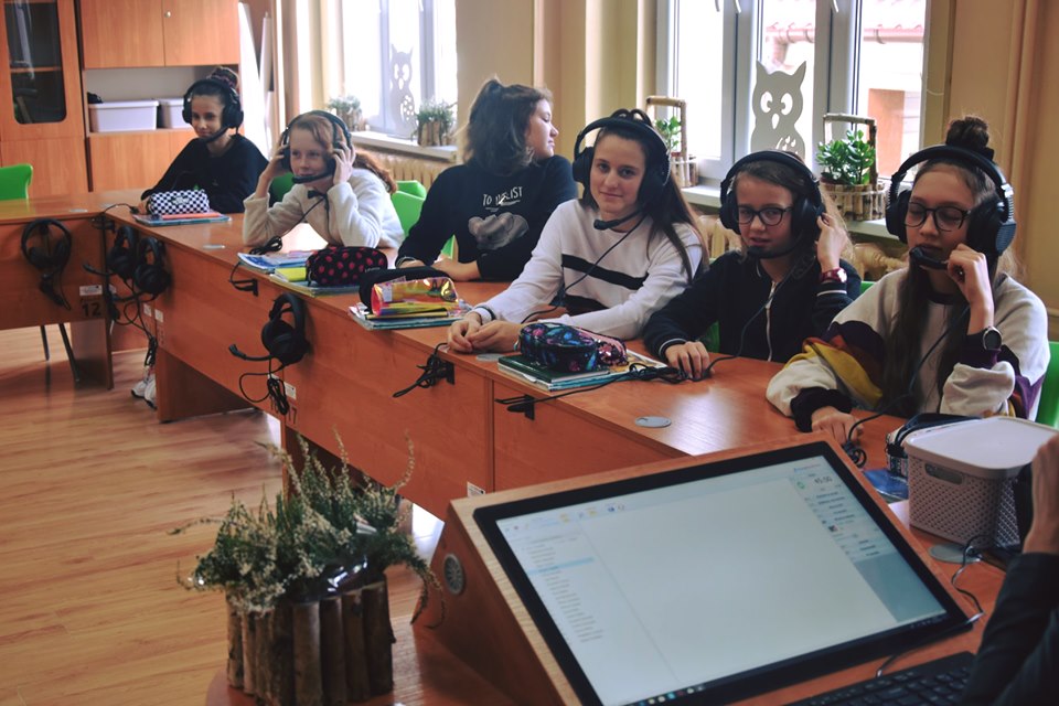 Powiększ zdjęcie. Uczennice ze słuchawkami na uszach