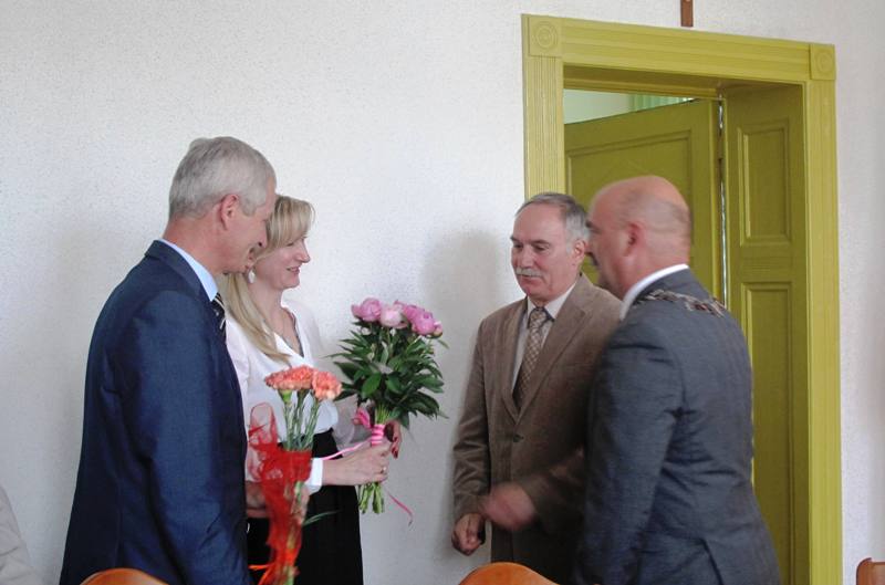Iwona pludra Skarbni oraz Piotr Downar odbierają kwiaty od Adama Kaczmarczyka Przewodniczącego  Komisji Oświaty oraz Pawła Chrobaka Przewodniczącego rady Miejskiej w Dębnie (link prowdzi do powiększonej wersji zdjęcia)